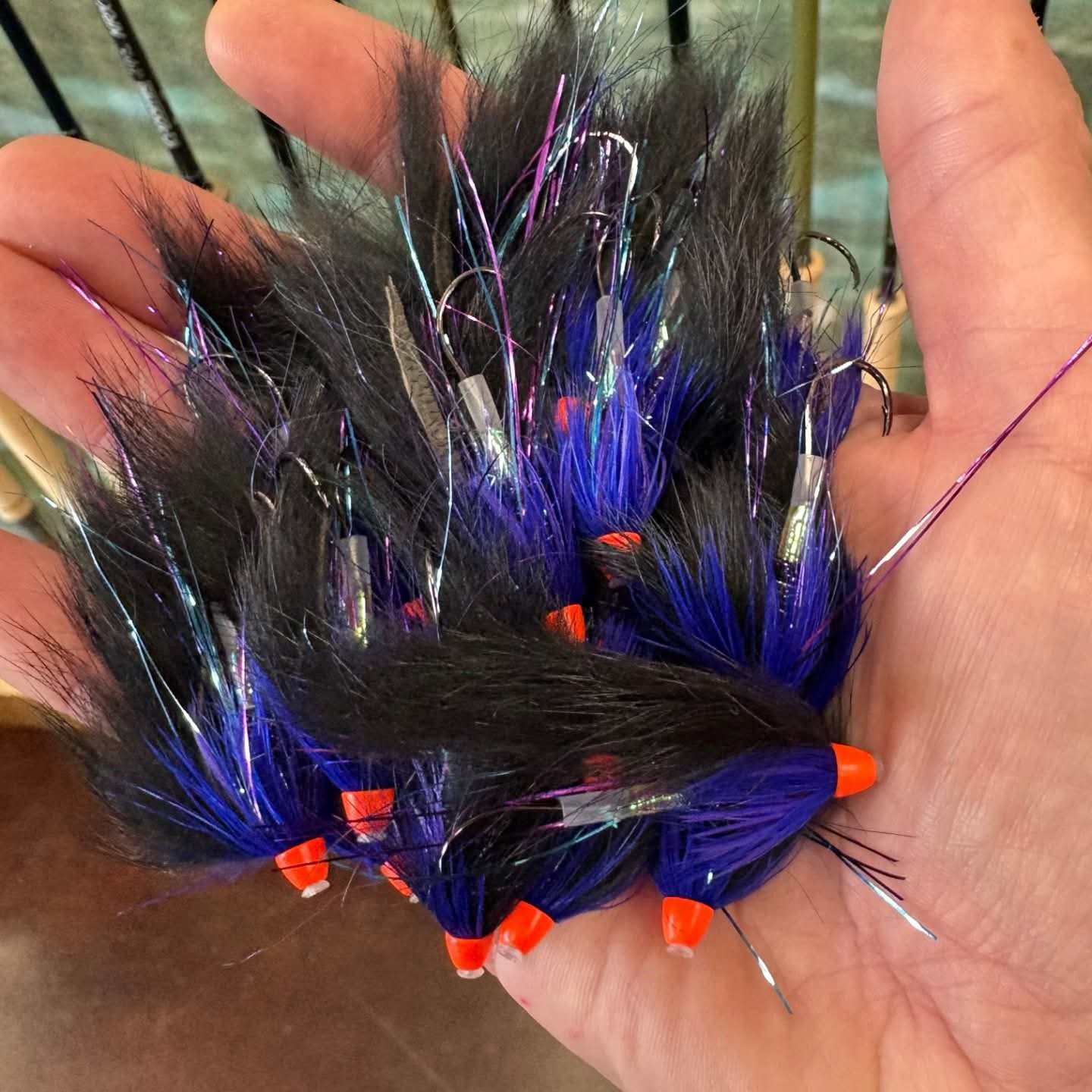 Hand holding a bundle of Bunny Hare Leech -
with black, blue, and orange colors.