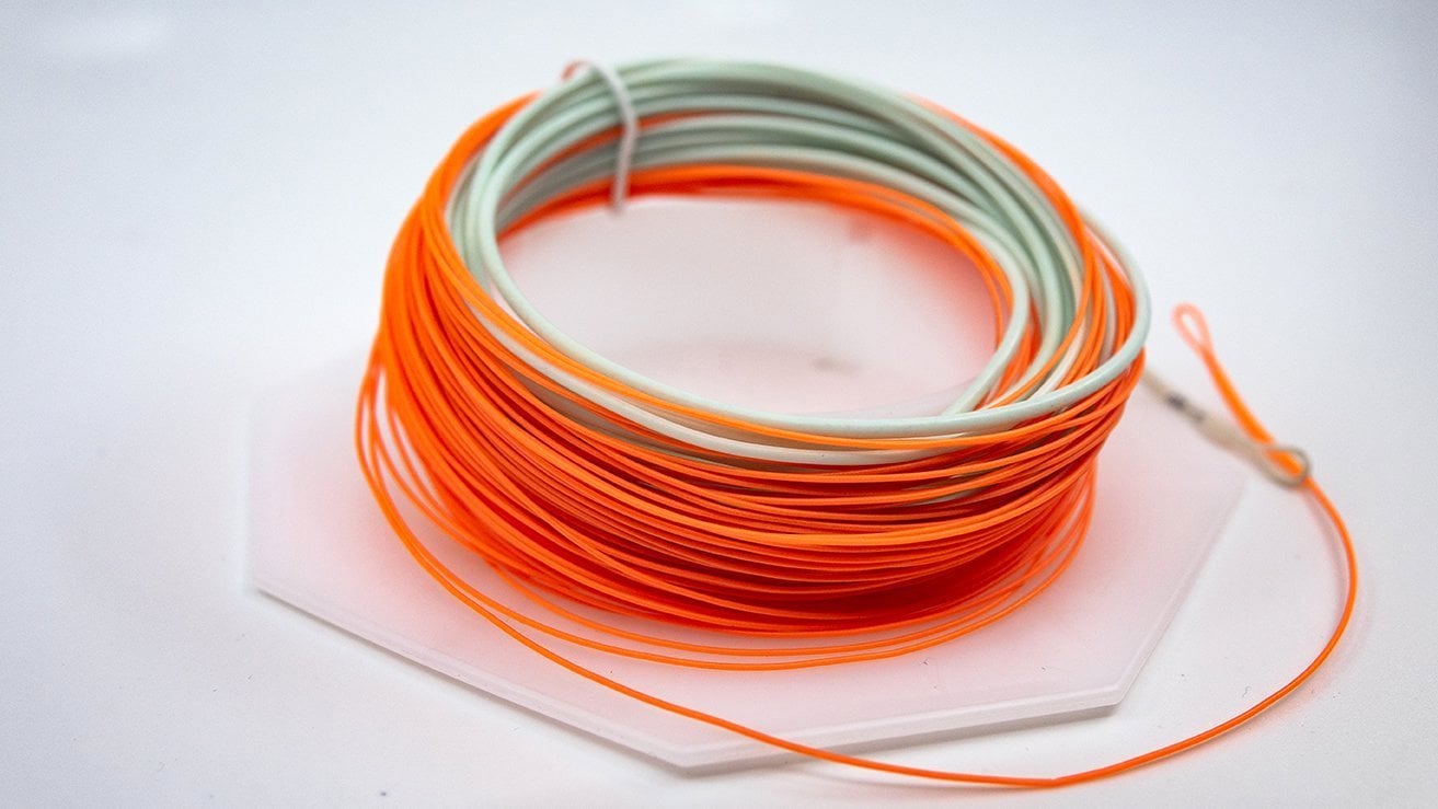 Coiled orange and green fishing line on a white background
