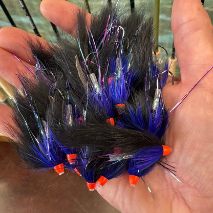 Hand holding a bundle of  Bunny Hare Leech -
with black, blue, and orange colors.