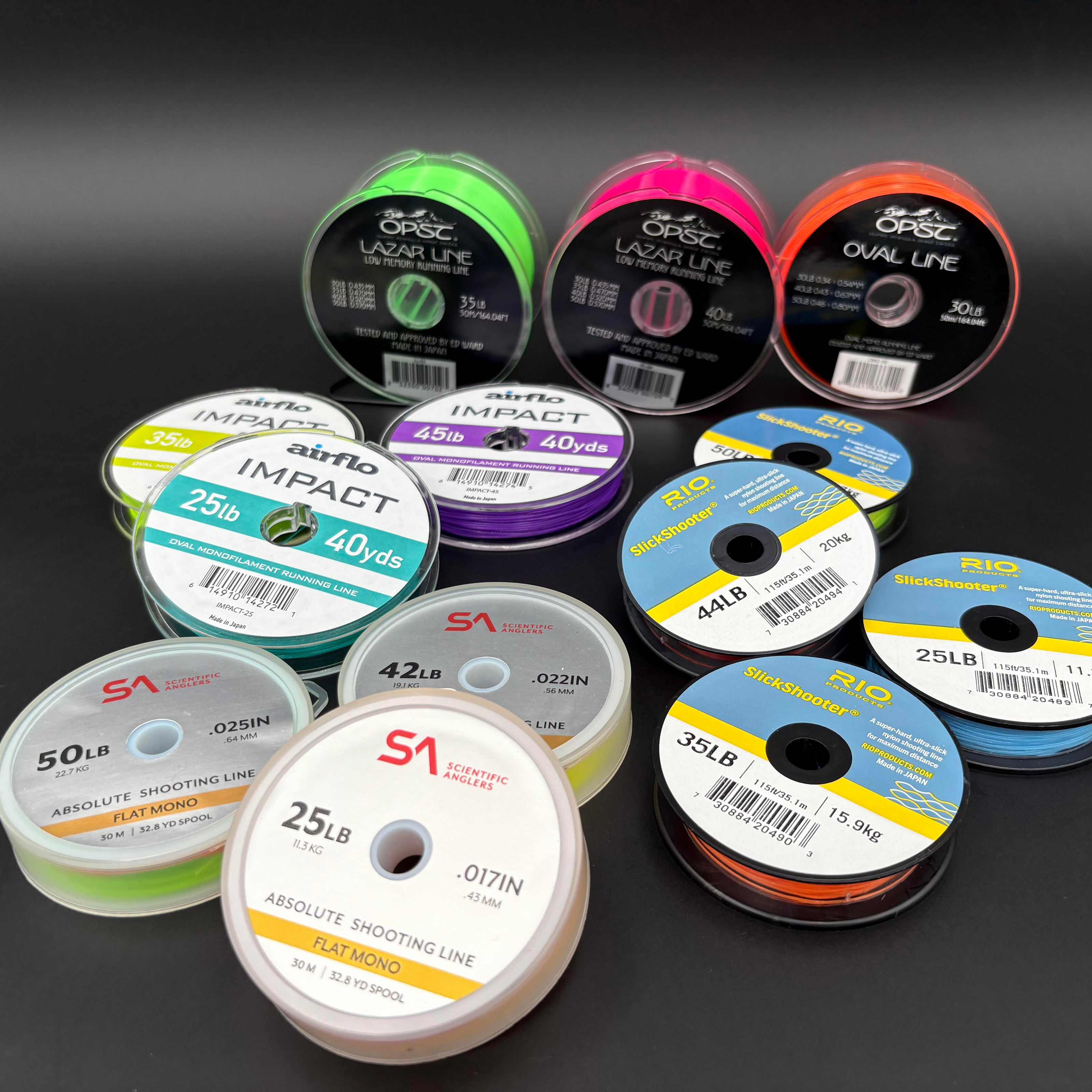 Collection of fishing line spools with various brands and labels on a dark background