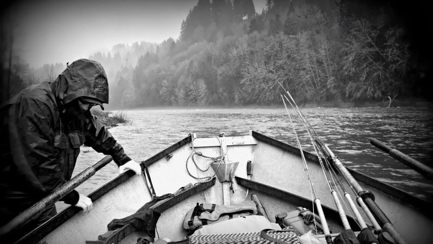 Person fishing from a boat on a lake with trees in the background
